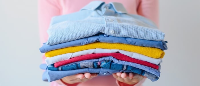 girl-holding-pile-of-washed-and-ironed-clothes